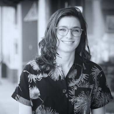 Emily Morris, motion graphic designer of Kino Mountain Productions, smiling on the street in downtown Apex, North Carolia.