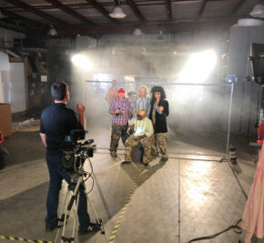 A group of men standing in front of a fence on a video shoot at Seizmik in Fuquay-Varina, North Carolina.